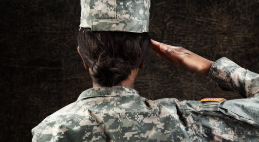 woman in military uniform saluting from behind