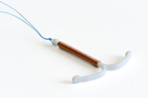 Copper IUD on white background