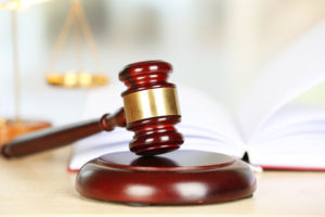 Wooden gavel with blurred scales of justice in the background