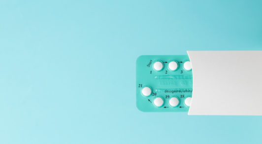 Pack of oral contraceptive pills with instructions. Blister in white case on blue background
