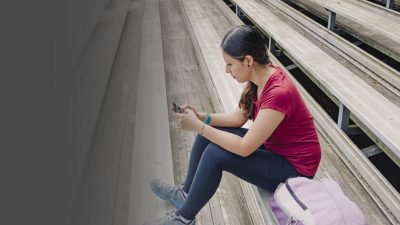 Image Of A Young Hispanic Woman On Her Smart Phone, Dramatic Perspective Seating Of Bleachers