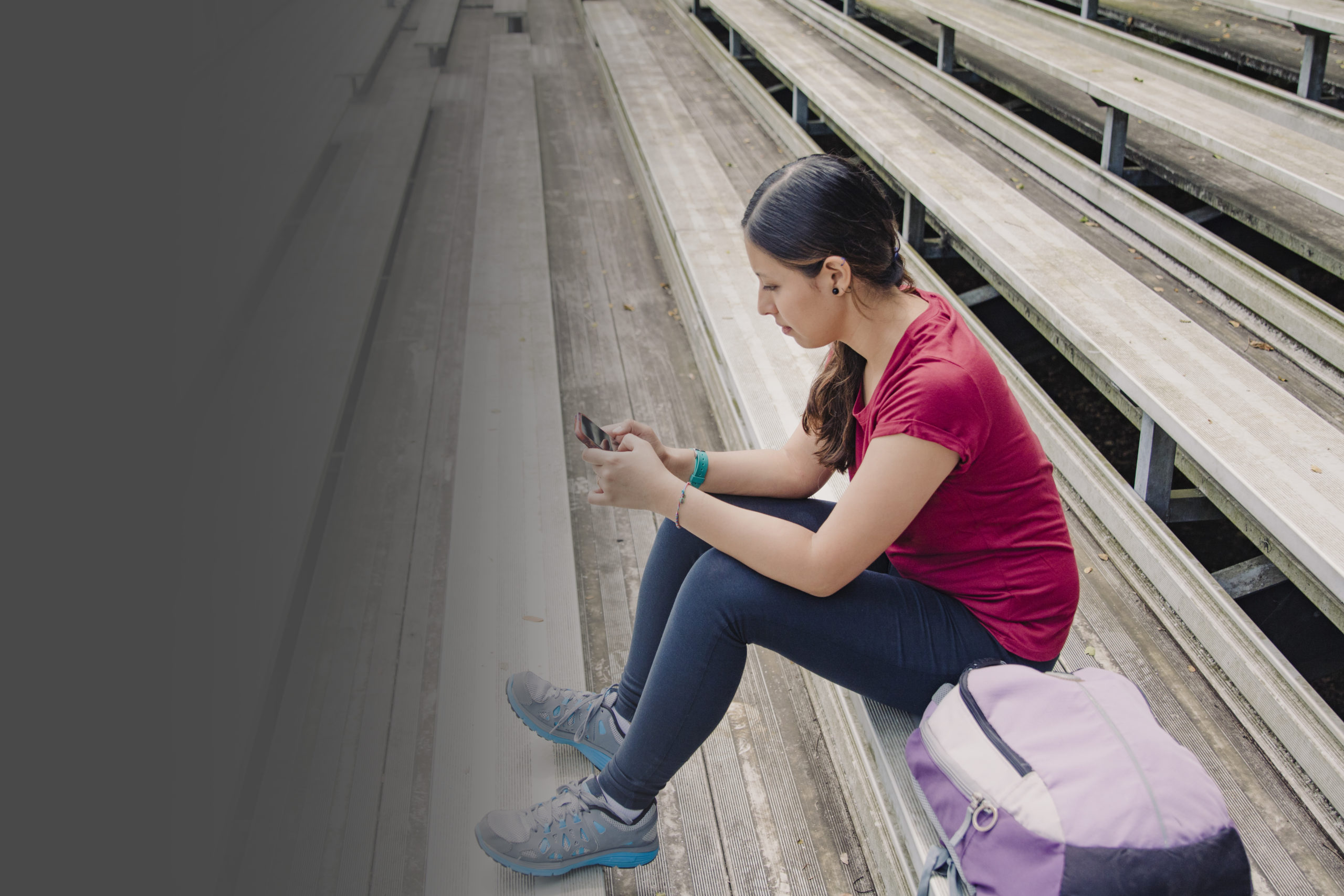 Image Of A Young Hispanic Woman On Her Smart Phone, Dramatic Perspective Seating Of Bleachers