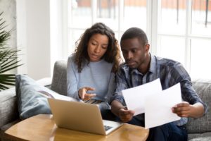 Serious African American couple discussing paper documents,