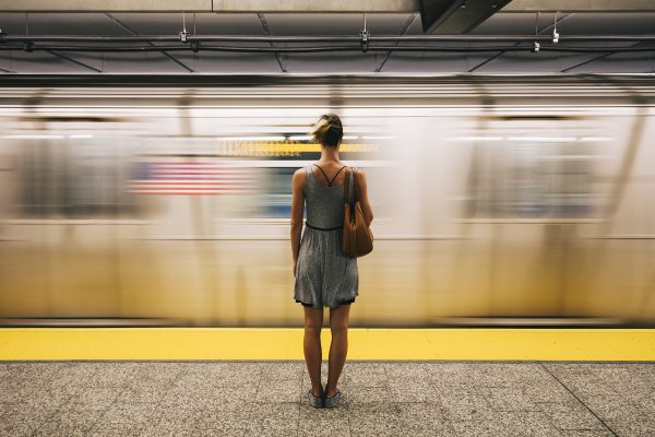 Young woman waiting for subway train in New York City, USA